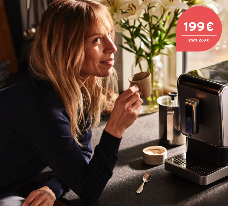 Stimmungsvolles Bild einer in die Kamera lachenden Frau, die sich über ihren Kaffee aus dem Esperto Caffè freut.