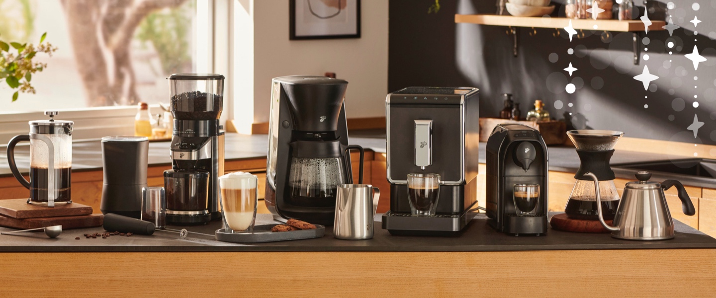 Ein stimmungsvolles Bild einer lachenden Frau, die ihren Kaffee zubereitet leitet den Einstieg auf die Kaffeemaschinen und -bereiter Seite ein. Entdecken Sie hier für jede Zubereitungsart die passende Maschine.