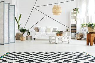 Schwarz-weißer Teppich in einem hellen, mit weißen Möbeln eingerichteten Wohnzimmer.