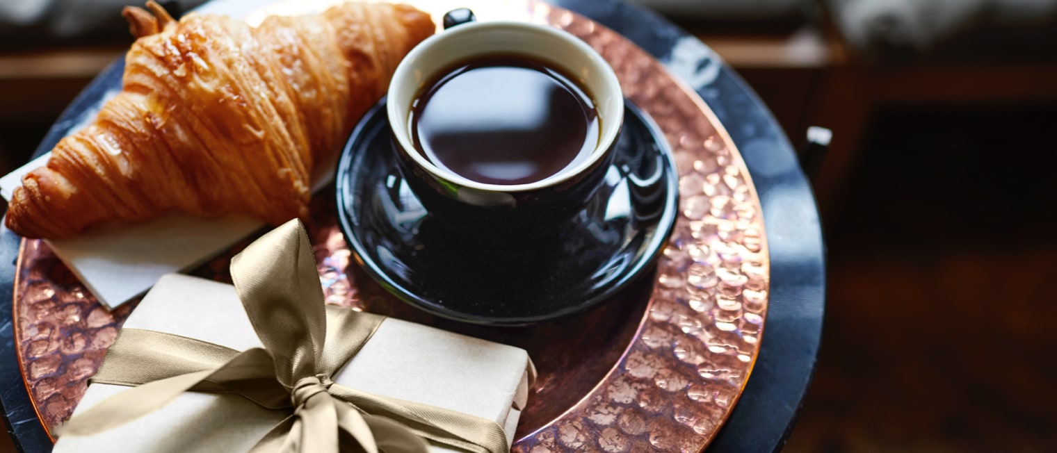 Glas Kaffee steht mit Geschenk auf einem Tisch','Enter picture alt'}