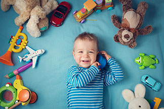 Ein Baby liegt auf einer Decke und trägt einen gestreiften Pullover.