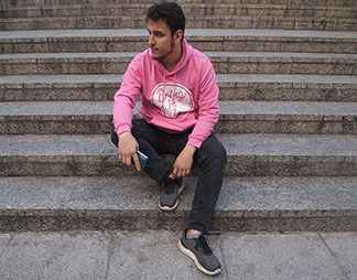 Ein Mann trägt einen pinken Kapuzenpullover.