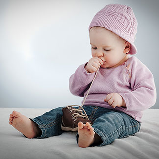 Ein Baby trägt einen rosa Pullover.