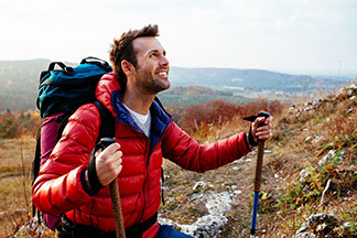Eine Mann trägt eine Outdoorjacke beim wandern.