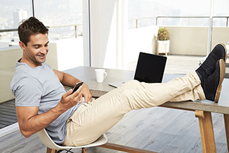 Ein Mann sitzt im Büro und trägt ein beige Chino.