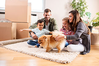 Eine Familie spielt mit Ihrem Hund.