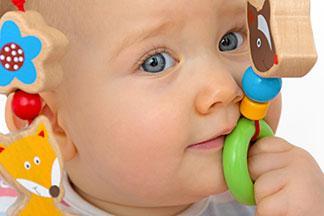 Ein Baby beißt in ein Baby-Beißring