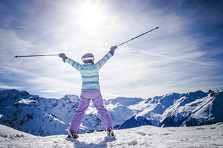 Eine Skifahrerin steht auf dem Berg.