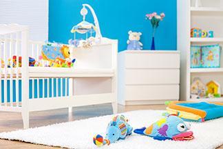 Man sieht ein Kinderzimmer mit weißen Möbeln.