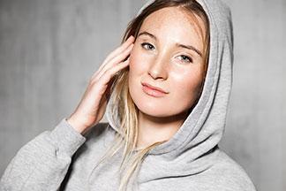 Eine Frau trägt eine große graue Sportjacke.
