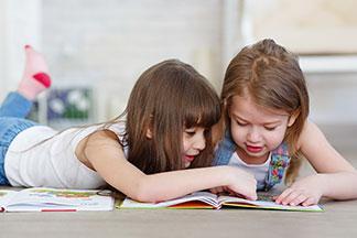 Zwei Kinder lesen in einem Buch