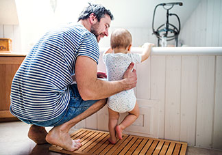 Ein Vater steht mit seinem Sohn vor einer Badewanne.