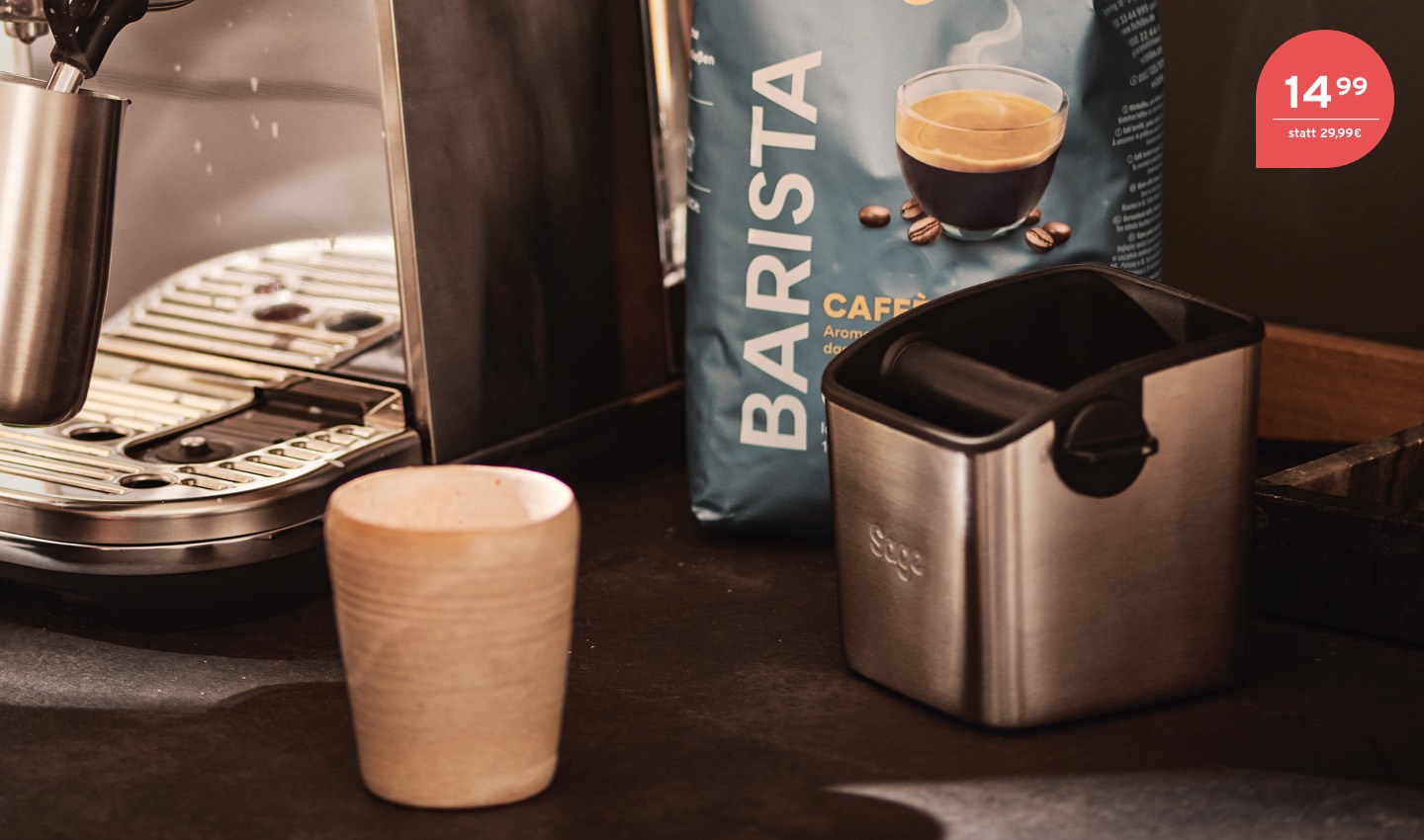Mann steht neben einer Siebträgermaschine und trinkt einen Kaffee