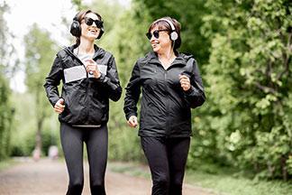 Zwei Frauen gehen mit ihren schwarzen Sportklamotten laufen.