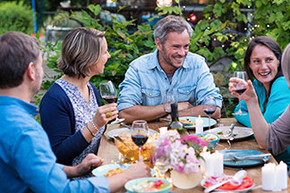 Eine Familie sitzt im Garten an einem gedeckten Tisch.