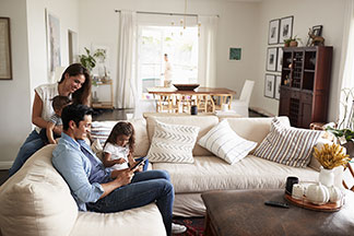 Eine Familie sitzt im Wohnzimmer.