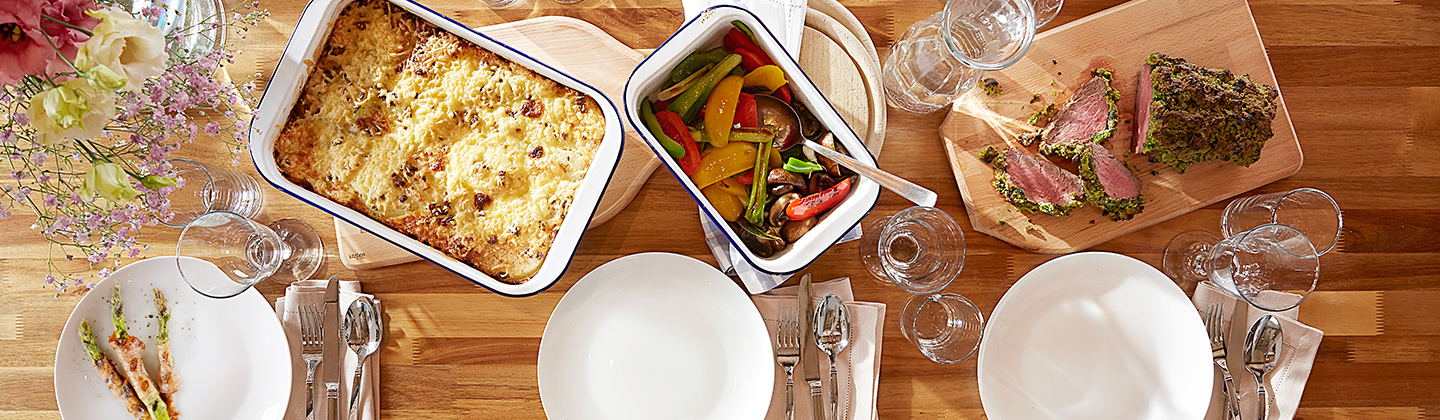 Gedeckter Tisch mit Auflauf und Spargel