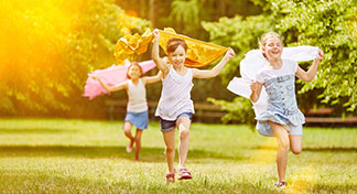 Kinder rennen durch einen Garten.