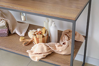 Waschbecken mit Unterschrank für bessere Ordnung: Eine geöffnete Schublade eines Waschbecken-Unterschranks in der Kosmetika wie Lipgloss, Wattepads und eine Cremedose stehen.