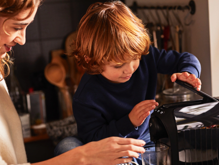 Finger betätigt Espresso Knopf an der weißen Cafissimo easy
