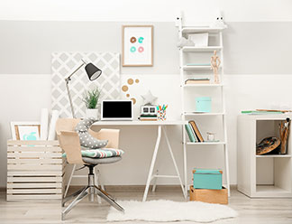 Büroausstattung in guter Qualität: Ein Arbeitszimmer mit weißem Schreibtisch, einem weißen, hohen, offenen Regal und einem Bürostuhl.