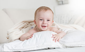 Ein Baby liegt in einem Bett.