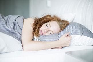 Eine Frau schläft im Bett.