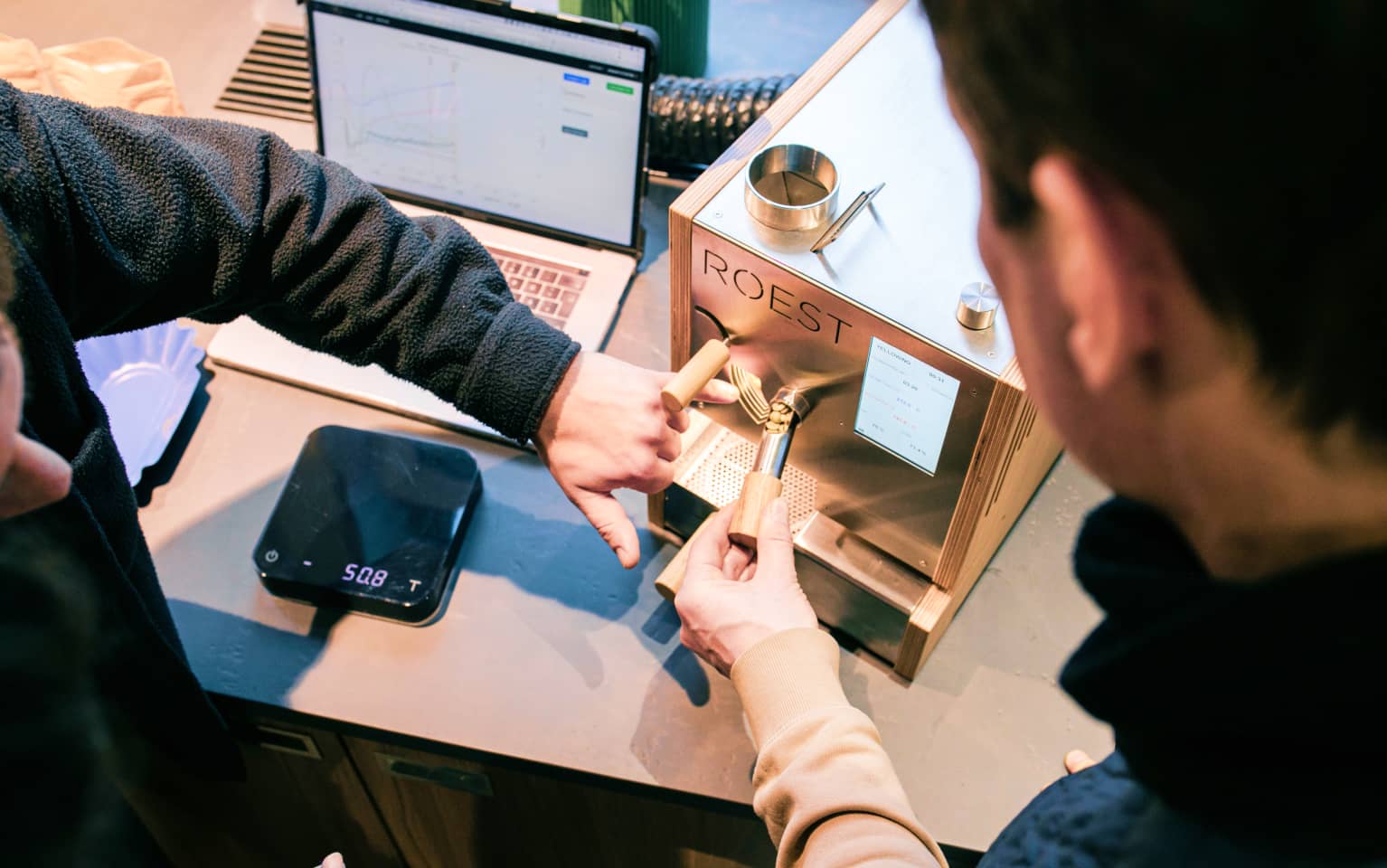 Zwei Personen arbeiteten mit einer Röstermaschine