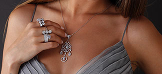 Eine Frau trägt Silberschmuck um den Hals und am Arm.
