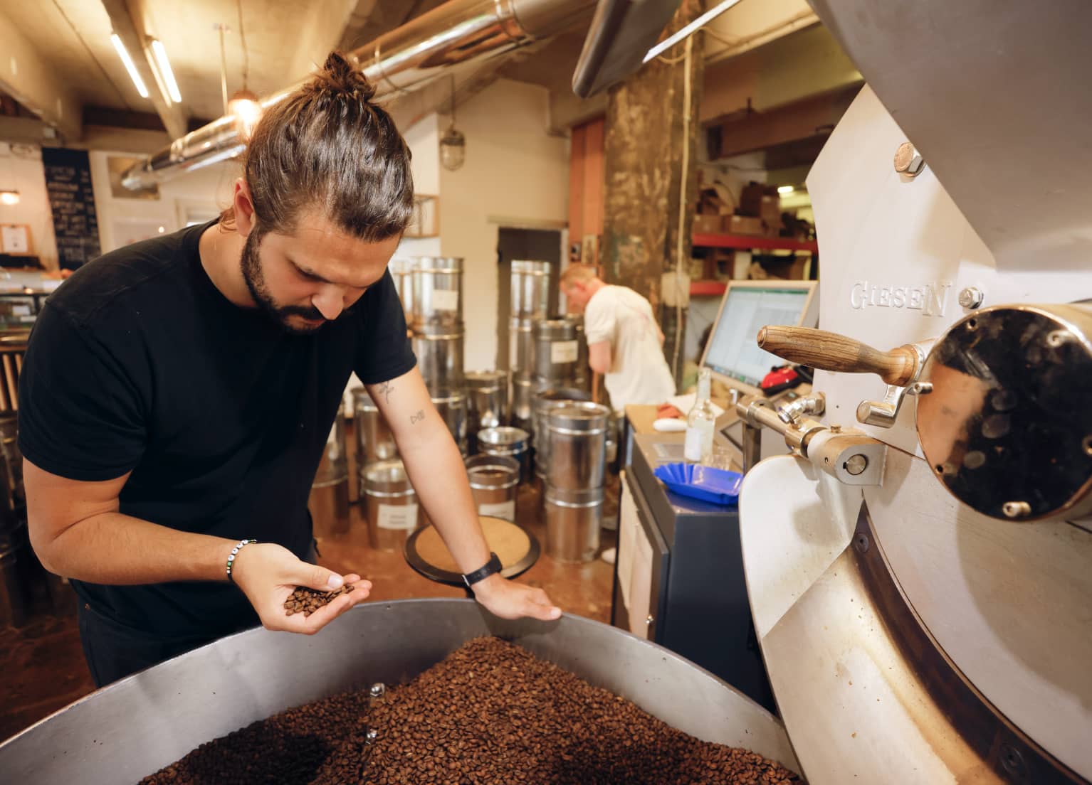 Ein Mitarbeiter der Rösterei Heilandt untersucht Kaffeebohnen in seiner Hand