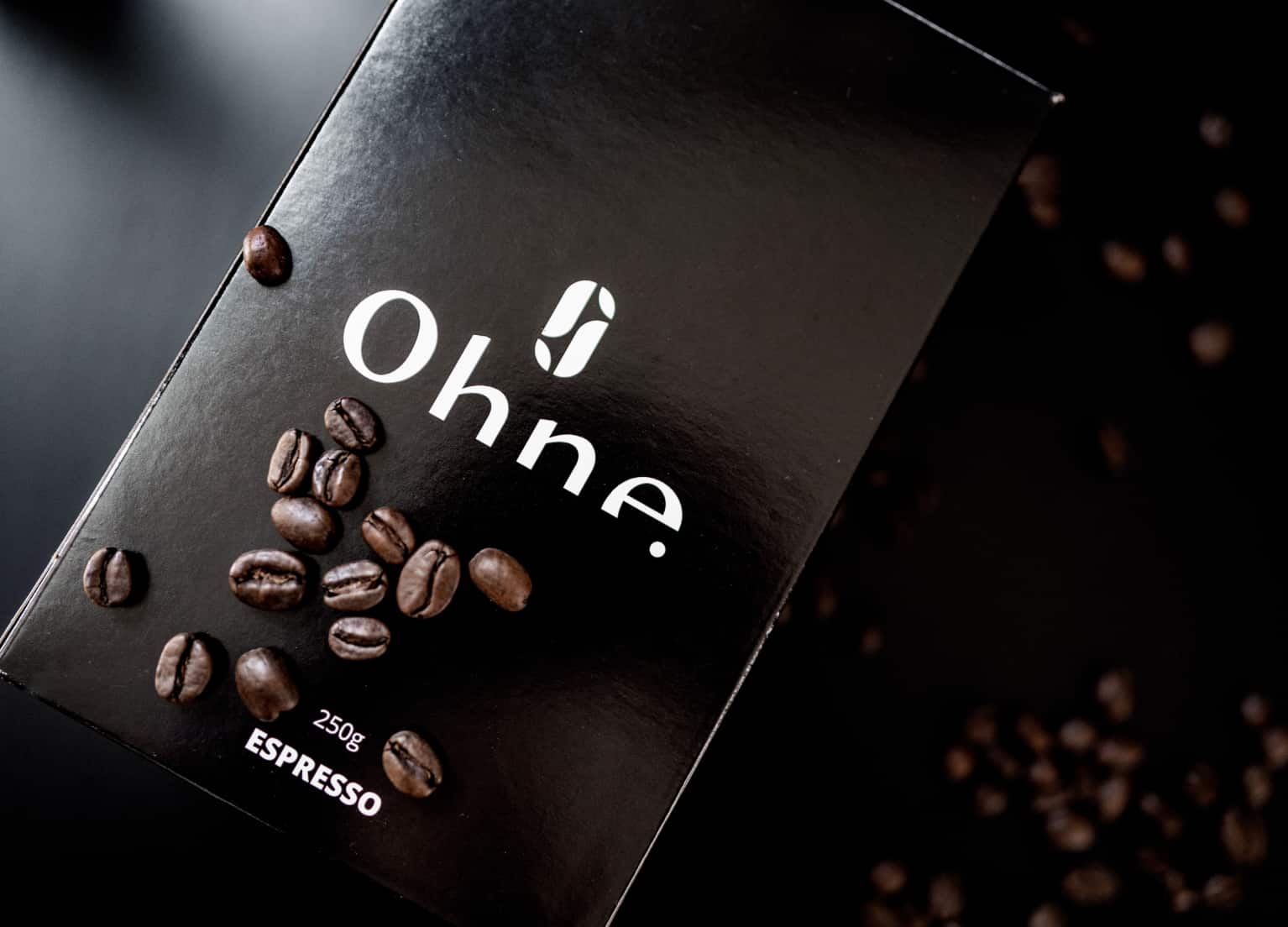 Eine Packung Kaffee der Rösterei OHNE Coffee, auf der Kaffeebohnen liegen
