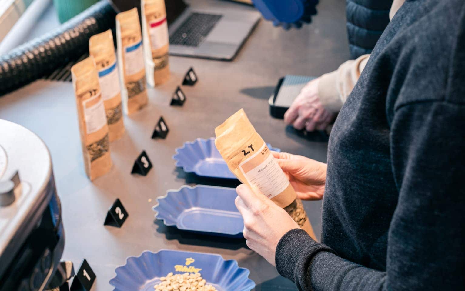 Eine Person hält eine Packung mit Kaffee-Sample in der Hand.