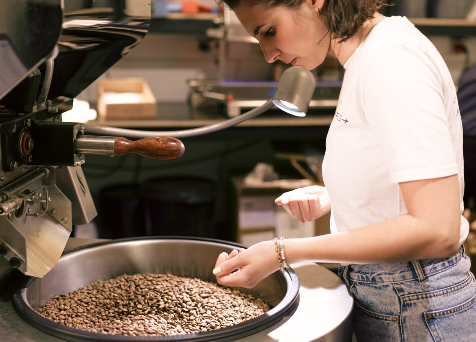 Gina betrachtet einen mit Kaffeebohnen befüllten Behälter