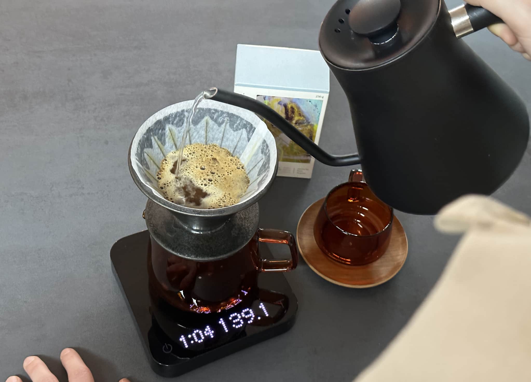 Kaffee wird aus einem Schwanenhalskessel in einen Filter gegossen