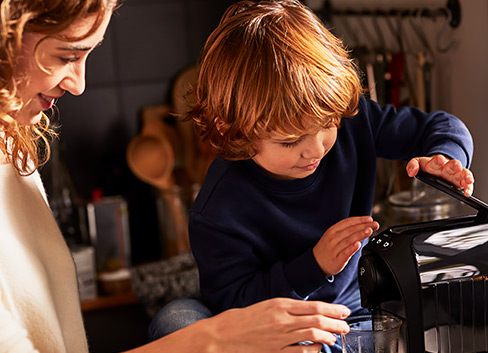 Finger betätigt Espresso Knopf an der weißen Cafissimo easy