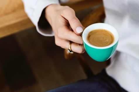Jemand hält eine Tasse Espresso un der Hand
