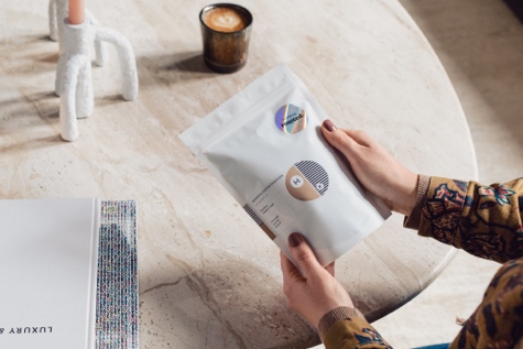 Frau hält eine Packung Specialty Coffee in den Händen