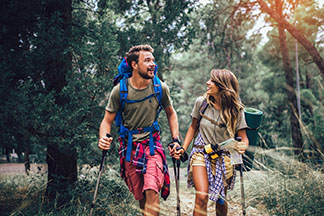Auf in den Abenteuerurlaub: Ein junges Paar geht Wandern.