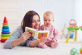 Eine Mutter liest ihrem Baby aus einem Kinderbuch vor.