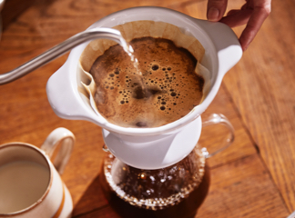 Filterkaffee wird in einem Keramikfilter aufgegossen
