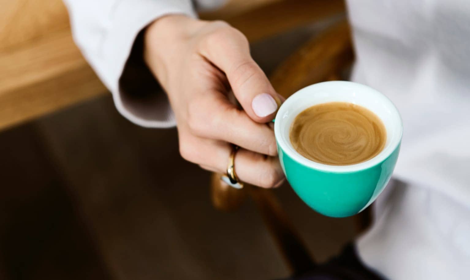 Jemand hält eine Tasse Espresso in der Hand