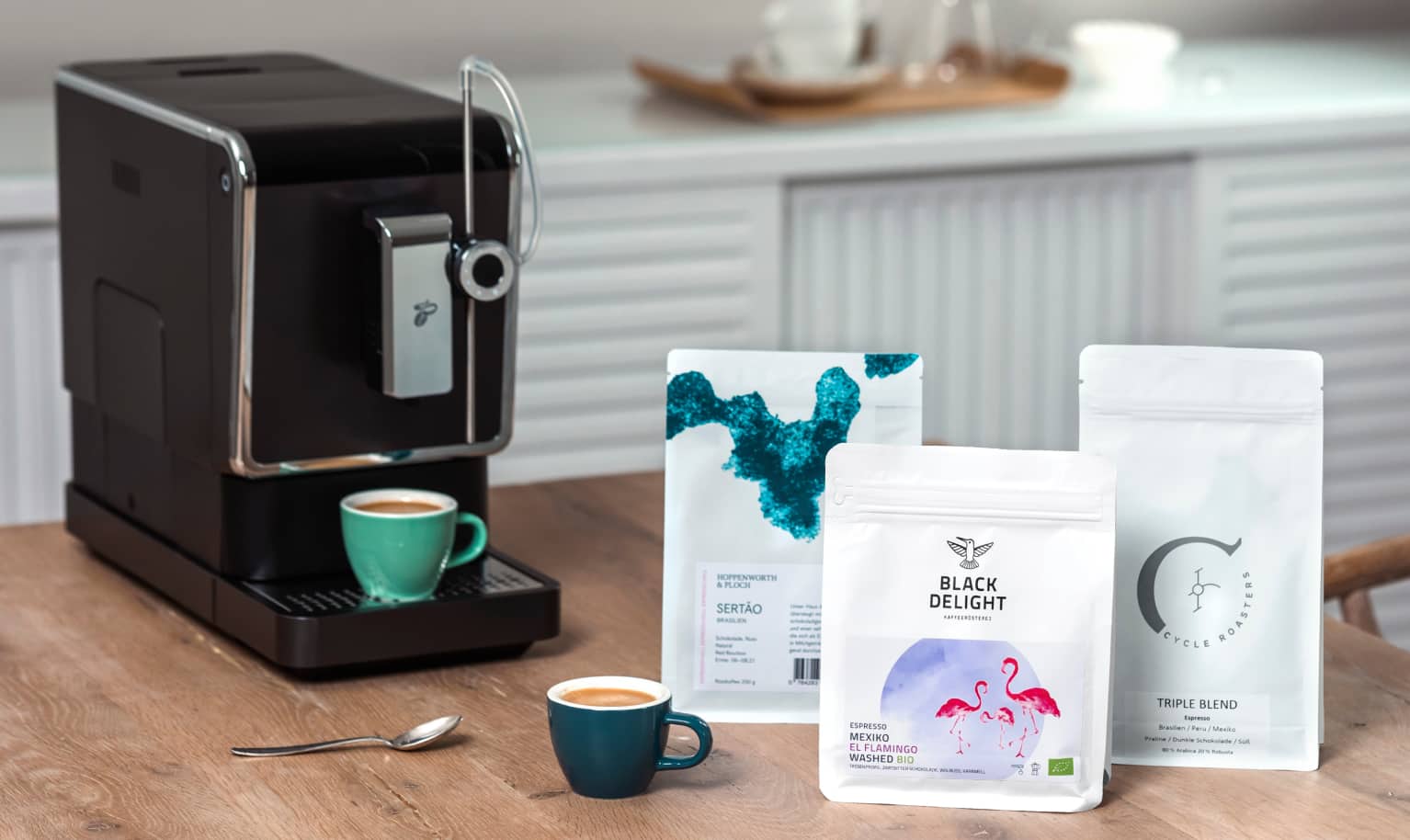 Drei Specialty Coffees stehen neben dem Vollautomaten