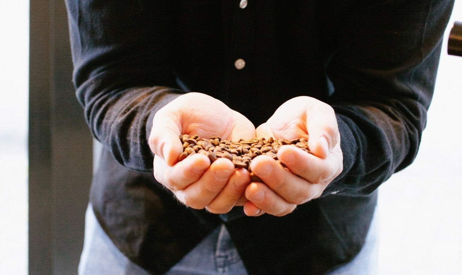 Philipp von KABO Kaffee hält Kaffeebohnen in der Hand