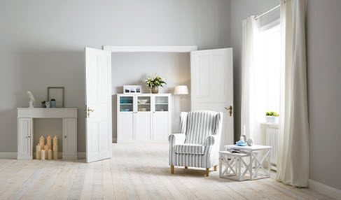Die richtige Beleuchtung im Wohnzimmer: Verschiedene Lichtquellen sorgen in einem großen Wohnzimmer mit einem weiß-blau-gestreiften Sessel.