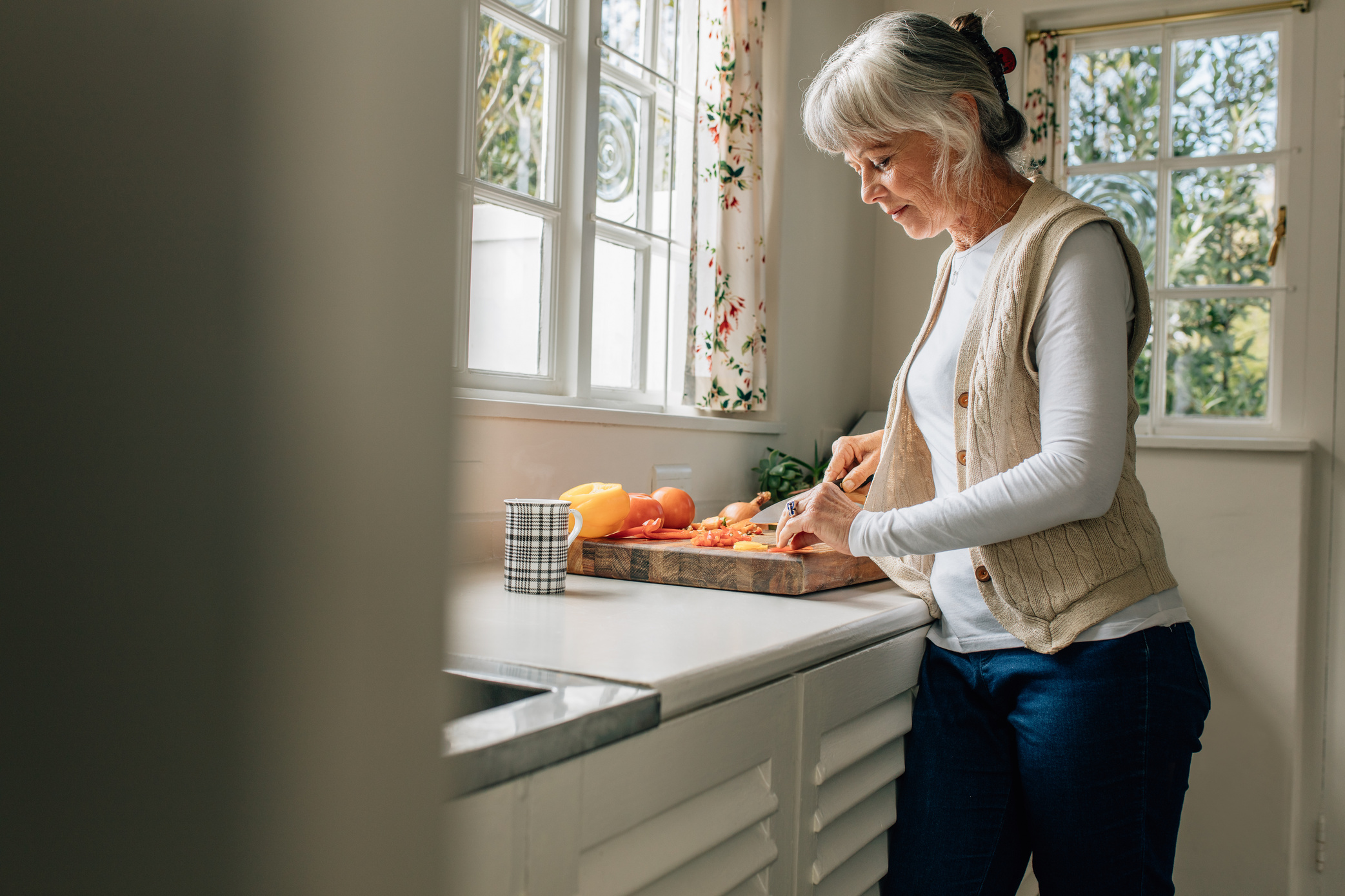 Ältere Frau kocht zu Hause in der Küche