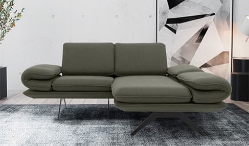 Ein modernes Wohnzimmer wird durch ein dunkelgrünes Ecksofa ergänzt.