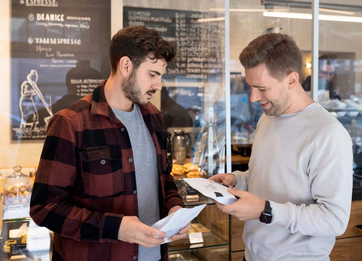 Zwei Kaffeeexperten halten Speciality Coffee in ihrer Hand und tauschen sich fachkundig aus.
