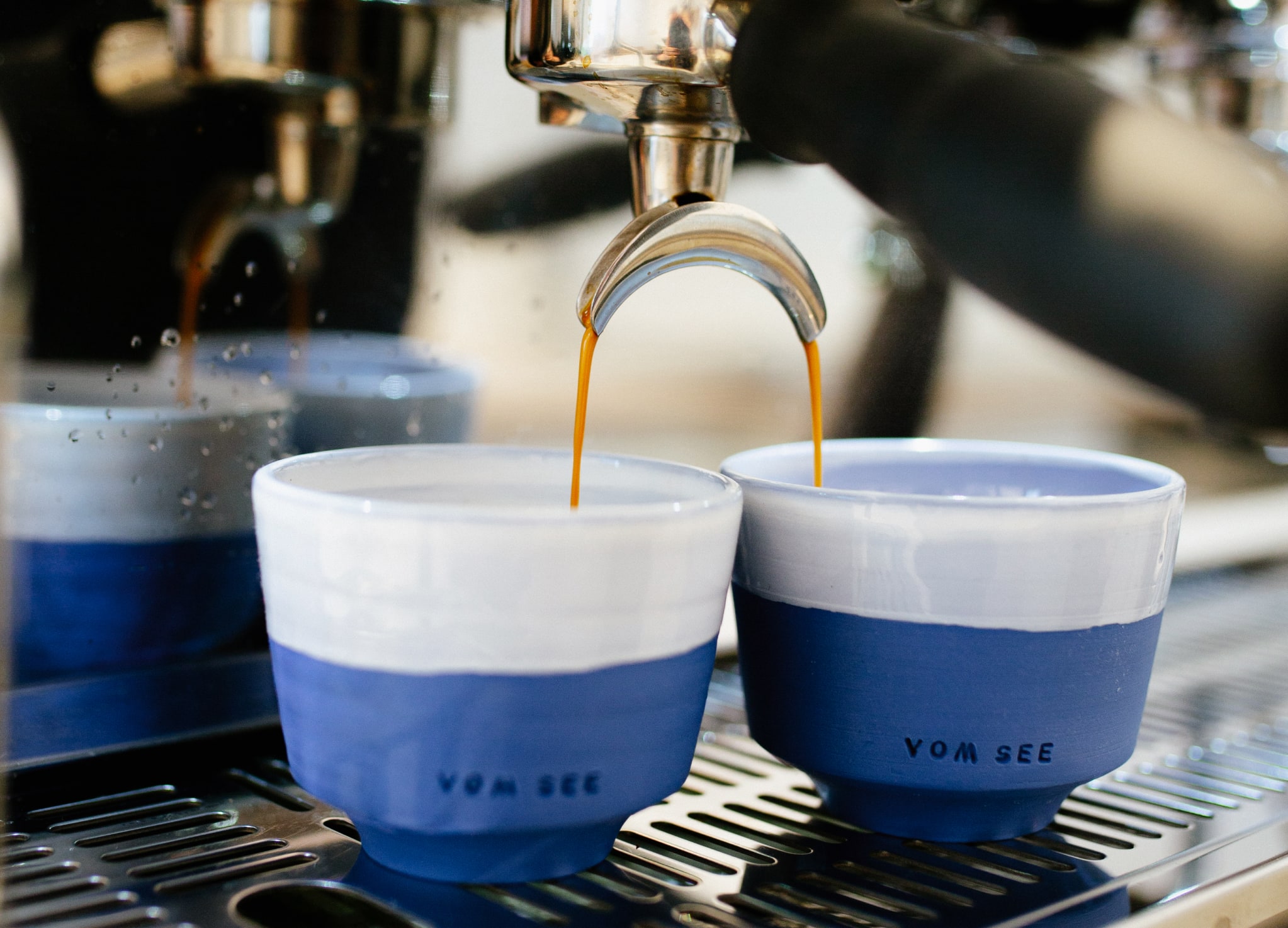 Kaffee läuft in zwei Kaffeetassen