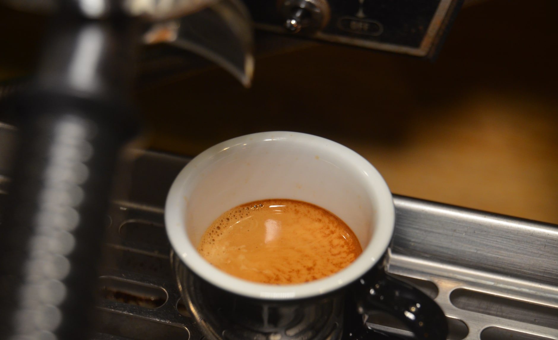 Kaffee läuft aus einem Siebträger in eine Kaffeetasse