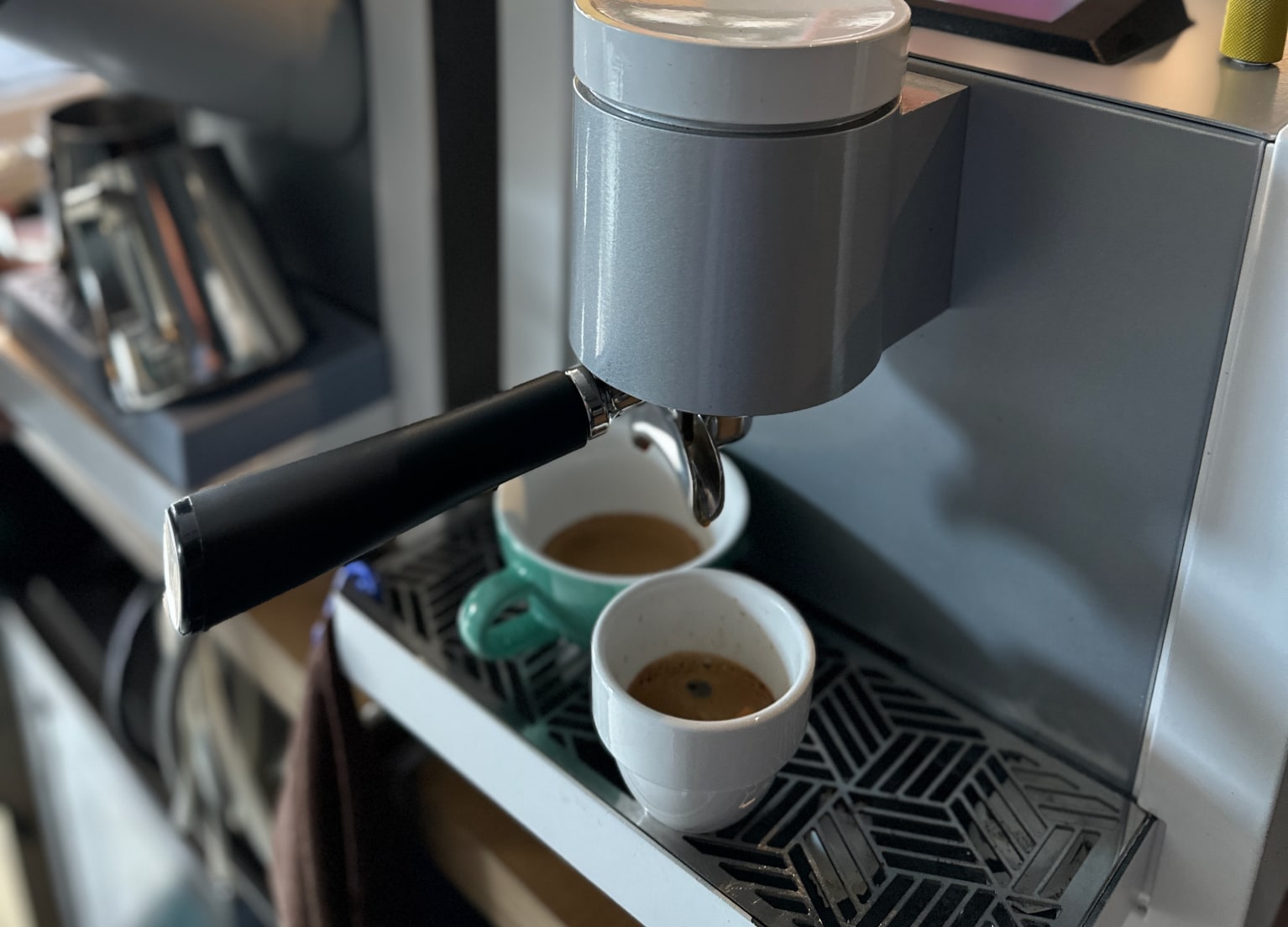 Zwei Espressotassen unter einem Siebträger mit Kaffee gefüllt